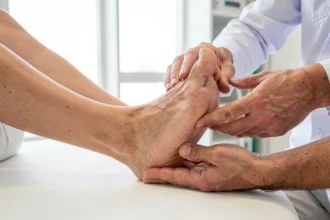 Médecin examinant la voûte plantaire d'un patient en cabinet